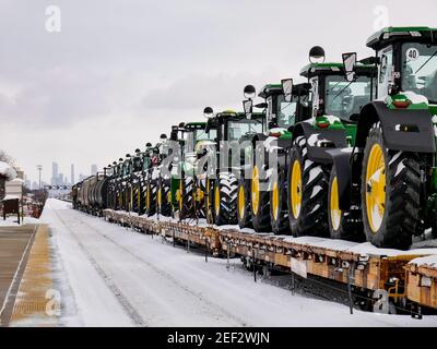 Eisenbahnwaggons, die mit John Deere-Traktoren für den Export beladen sind. Oak Park, Illinois. Downtown Chicago in der Ferne. Stockfoto