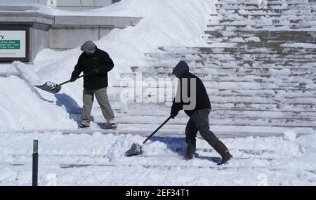 St. Louis, Usa. Februar 2021, 16th. Am Dienstag, den 16. Februar 2021, räumen Männer 8 cm Schnee von der Haupttreppe der St. Louis-Bibliothek in der Innenstadt von St. Louis. Foto von Bill Greenblatt/UPI Kredit: UPI/Alamy Live News Stockfoto