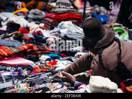 AREQUIPA, PERU - 19. JANUAR 2018: Unbekannte peruanische Mutter, die handmades-Textilien und Handarbeiten an Touristen im Colca-Tal, Peru verkauft Stockfoto