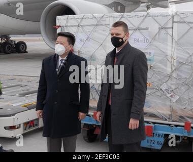 Budapest, Ungarn. Februar 2021, 16th. Tamas Menczer (R), Staatssekretär des ungarischen Ministeriums für Auswärtige Angelegenheiten und Handel, und der chinesische Botschafter in Ungarn Qi Dayu begrüßen die erste Charge des chinesischen Sinopharm COVID-19-Impfstoffs, der von Ungarn am Liszt Ferenc International Airport in Budapest, Ungarn, am 16. Februar 2021 erworben wurde. Die erste Charge des von Ungarn erworbenen chinesischen Sinopharm COVID-19-Impfstoffs kam am Dienstag in Budapest an. Quelle: Attila Volgyi/Xinhua/Alamy Live News Stockfoto