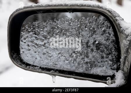 Der Rückspiegel ist mit Schnee bedeckt.Schneesturm Uri fegte vom 12th. Bis 16th. Februar über die Vereinigten Staaten in Schnee und Eis. URI begann im pazifischen Nordwesten und ging den ganzen Weg in den Südosten der USA. Durch Autounfälle und niedrige Temperaturen hat der Sturm viele Menschenleben gefordert. In Athens County Ohio begann der Sturm am Montagmorgen, den 15. Februar 2021 und hat sich bis Dienstag, den 16. Februar 2021 fortgesetzt. Derzeit Athens County ist unter einer Ebene zwei Schnee Notfall. Stockfoto