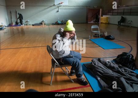 Austin, Texas, USA. Februar 2021, 16th. PATRICIO MARTINEZ, der obdachlos ist und vor der extremen Kälte des texanischen Schneesturms flieht, hört in einer kirchlichen Notklinik in Austin Radio. Ein historischer Schnee von 8 Zoll gepaart mit bitterkalten Temperaturen haben Hunderte von Menschen gezwungen, sich im Freien zu beherbergen. Quelle: Bob Daemmrich/ZUMA Wire/Alamy Live News Stockfoto