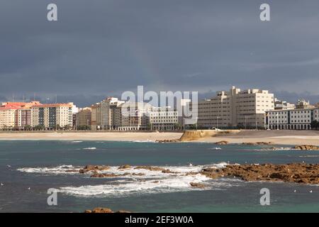 Ein Coruna-Spanien. Gesamtansicht der Strände von Raizor und Orzan mit den Gebäuden der Stadt im Hintergrund bei Sonnenuntergang an einem stürmischen Tag Stockfoto