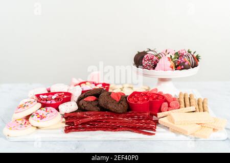 Valentinstag Käseplatine mit verschiedenen Keksen und Süßigkeiten. Stockfoto