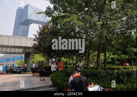 16,08.2012, Peking, China, Asien - Menschen im zentralen Geschäftsviertel Guomao der Hauptstadt mit dem Neubau des CCTV-Hauptquartiers. Stockfoto