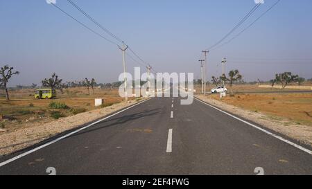 10. Februar 2021- Sikar, Jaipur, Indien. Transport Straße und Verkehrskonzept. Schwarze Asphaltstraße zum Horizont mit blauem Himmel Wolke Natur. Stockfoto