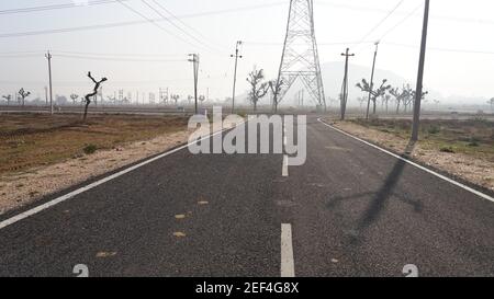 10. Februar 2021- Sikar, Jaipur, Indien. Leere Wüsten Autobahn führt zu verlassenen Feldern aus dem Land Indien. Straße ohne Verkehr. Stockfoto