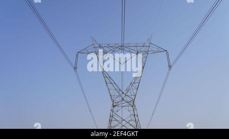 Nahaufnahme der industriellen Stromversorgungsleitungen. Hochspannungs-Strom durch große Eisenstangen. Leitungsansicht der Stromkabel. Stockfoto