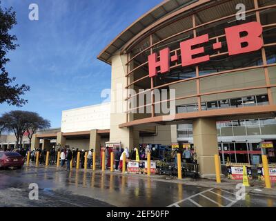 Austin, Texas - 15. Februar 2021: Eine lange Schlange umwickelt einen HEB-Supermarkt mit Schnee draußen Stockfoto