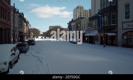 Austin, Texas - 15. Februar 2021: Schnee bedeckt eine gefrorene 6th Straße im Downtown Nachtleben Viertel Stockfoto