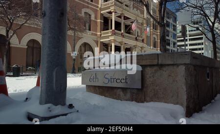 Austin, Texas - 15. Februar 2021: Das Straßenschild 6th ist nach einem texanischen Schneesturm im Winterschnee bedeckt Stockfoto