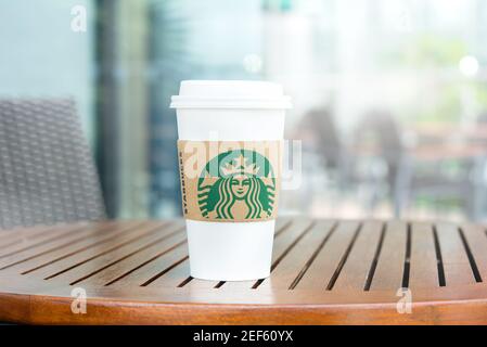 BANGKOK, THAILAND - JUN 29, 2016 : Starbucks Take Away Kaffeetasse auf Holztisch im Starbucks Coffee Shop Stockfoto