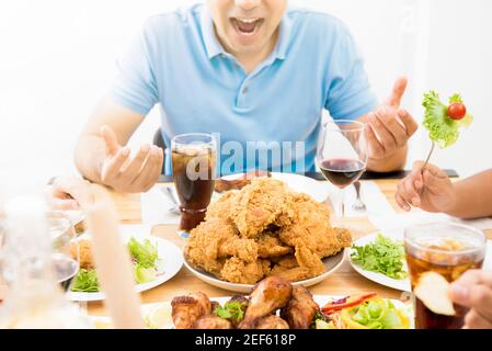 Essen und Getränke auf dem Esstisch vor aufgeregt Hungriger junger Mann Stockfoto