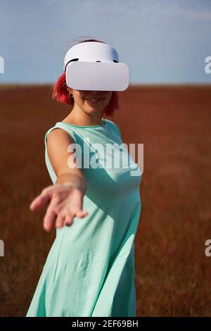 Frau geht in die virtuelle Realität mit Virtual-Reality-Headset. Das Konzept der virtuellen Realität, Simulationen, Verbindung und Kommunikation. Stockfoto