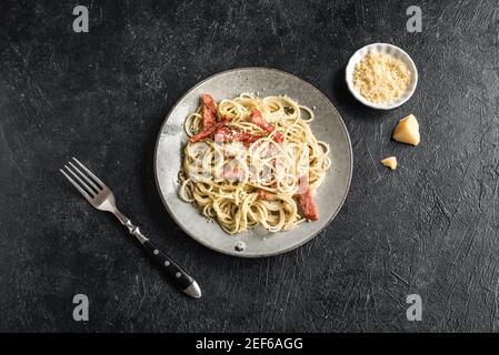 Carbonara Nudeln, Spaghetti mit Speck, Ei, Parmesan und Sahne Soße. Traditionelle italienische Küche. Pasta alla Carbonara, Ansicht von oben, Kopieren sp Stockfoto