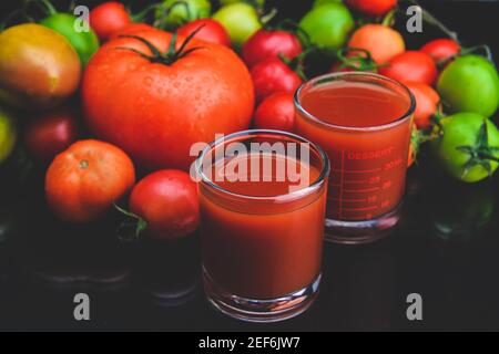 Mischen Sie Tomaten und Säfte in Glas mit schwarzem Hintergrund lowlighting. Stockfoto
