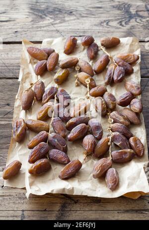 Die getrockneten Datteln die Früchte auf dem Zweig auf dem hölzernen Tisch. Traditionelle Fast Breaking, Muslime Abendessen während des heiligen Ramadan Stockfoto