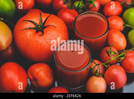 Mischen Sie Tomaten und Säfte in Glas mit schwarzem Hintergrund lowlighting. Stockfoto
