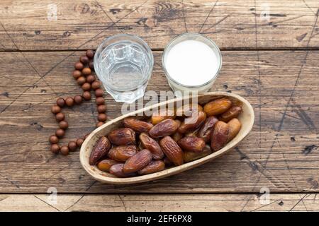 Die getrockneten Datteln die Früchte auf dem Zweig, die Gläser des Wassers und der Milch auf dem hölzernen Tisch. Traditionelle Fast Breaking, Muslime Abendessen während des heiligen Ramadan Stockfoto