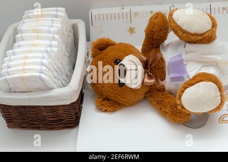 Pkture eines braunen Teddybären mit Windel auf dem Sitzen Im Babybett Stockfoto