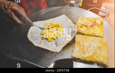 Indische Straßennahrung roti süßer Snack auf dem eisernen Teller mit Nachtbeleuchtung. Stockfoto