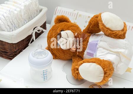 Pkture eines braunen Teddybären mit Windel auf dem Sitzen Im Babybett Stockfoto