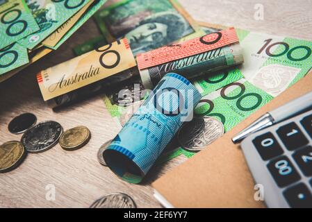 Geld, Australische Dollar (AUD), mit Notebook und Rechner auf dem Tisch - Finanz- und Anlagekonzepte Stockfoto