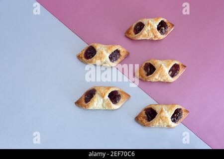 Auf einem zweifarbigen Hintergrund, köstliche Blätterteig Plätzchen gefüllt mit Himbeermarmelade. Draufsicht mit Kopierbereich. Flach liegend Stockfoto