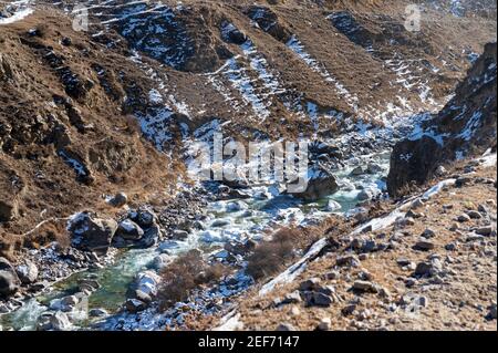 Natur in den Bergen des Kaukasus. Schöner Flusslauf und Steine im Winterschnee Stockfoto