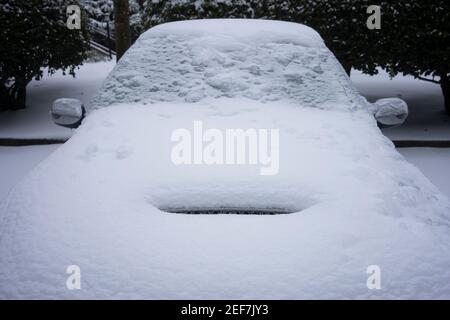 Vorderansicht eines gefrorenen Sportwagens auf den Straßen nach einem Wintersturm von Schnee und eiskalten Regen. Stockfoto