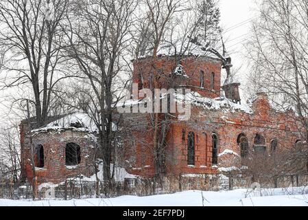Alte steinerne Kirchenfenster im alten russischen Stil. Vintage Wände einer Kirche mit abblätternden Ziegeln in Russland Stockfoto