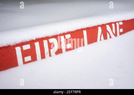 Lackierte Brandstreifen Bordsteinmarkierungen im Schnee. Stockfoto