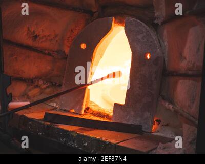 Glasbläserofen und traditionelle Werkzeuge in einer Glasmacherwerkstatt. Künstler macht durch traditionelle Glasbläserverfahren Stockfoto