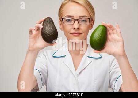 Ernährungsberater Arzt gesunde Lebensweise Konzept - Holding Bio Avocado Frucht Stockfoto