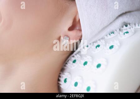 Frau liegt mit ihrem Hals auf Nadelrolle Stockfoto