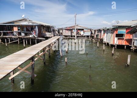 Küstenansicht des Armenviertels Kota Kinabalu, Malaysia. Kleine Holzhäuser und Stege auf Stelzen Stockfoto