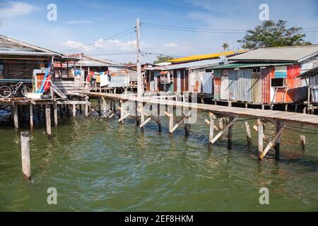 Küstenansicht des Armenviertels von Kota Kinabalu Stadt, Malaysia. Kleine Wohnhäuser und Stege auf Stelzen Stockfoto