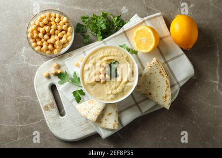 Konzept der leckeren essen mit Schüssel Hummus auf grau Hintergrund Stockfoto