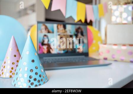 Kinder virtuellen Geburtstag, Home Party.Holiday Caps.Online-Konferenz, Videoanruf in Laptop, Computer.Friends Mädchen, Bildschirm Grüße.Dekoration, Geschenke, Luftballons Stockfoto