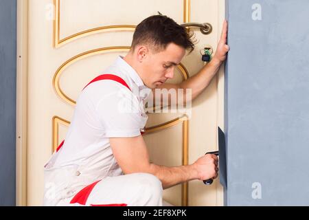 the plasterer is aligning wall using a special tool Stockfoto