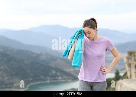 Müder Läufer trocknet Schweiß nach dem Sport Wandern in den Bergen Stockfoto