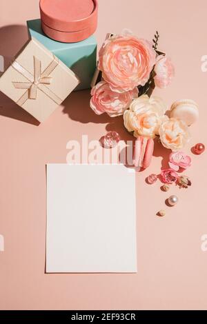 Abstrakter Hintergrund mit Blumen, Geschenkschachteln und einer Vorlage für Karten, Einladungen in pastellfarbenen gedämpften Farben. Trendig pastellfarben Pfirsich einfarbig. Flache Lay, Stockfoto