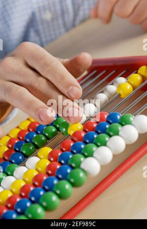 Nahaufnahme einer personÅ½s Hand, die Perlen auf einem Abakus zählt Stockfoto