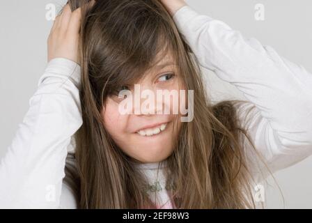 Nahaufnahme eines Mädchens mit den Händen im Haar Stockfoto