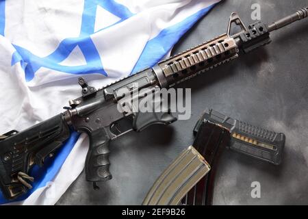 M4 Karabiner mit israelischer Flagge im Hintergrund. Yom Ha'atzmaut Unabhängigkeitstag in Israel Konzept Stockfoto