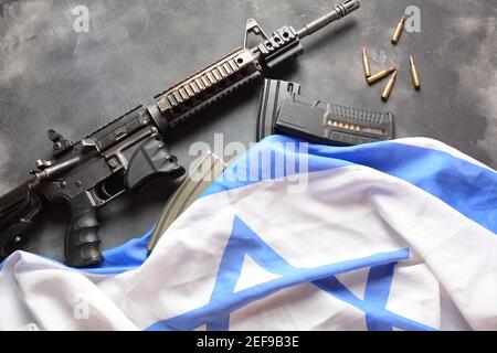 M4 Karabiner mit israelischer Flagge im Hintergrund. Yom Ha'atzmaut Unabhängigkeitstag in Israel Konzept Stockfoto