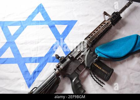 M4 Karabiner mit israelischer Flagge im Hintergrund. Yom Ha'atzmaut Unabhängigkeitstag in Israel Konzept Stockfoto