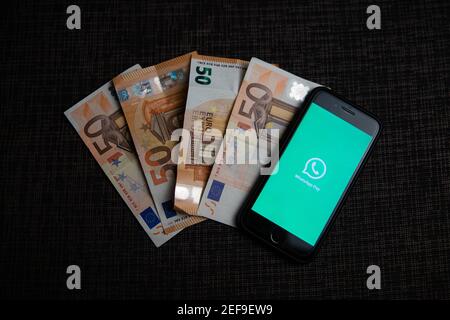 Ein Smartphone mit dem Whatsapp Pay Logo neben vier € 50 Rechnungen. Mit WhatsApp Pay können Sie direkt über die Messaging-App bezahlen und Geld senden Stockfoto