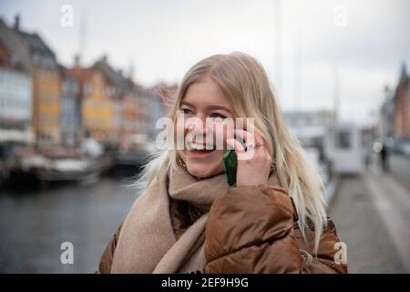 Attraktive Mädchen macht einen Anruf mit einem Freund und Lächelt glücklich, weil sie Nachrichten erhält, die sie mag Stockfoto