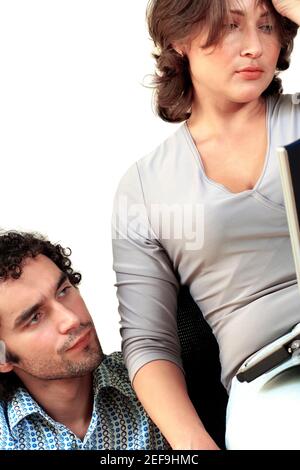 Junges Paar, das beim Arbeiten an einem Laptop nachdenkt Stockfoto
